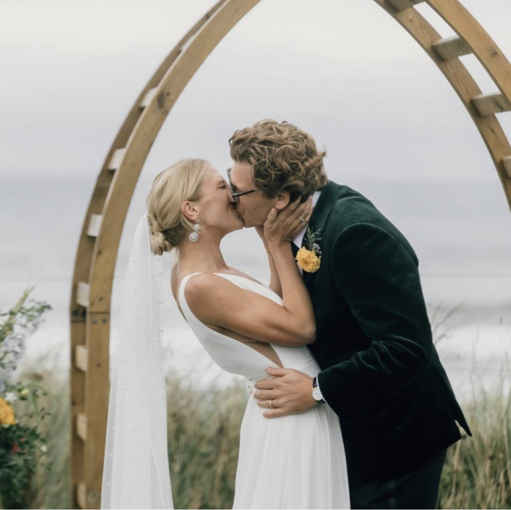 London couple sharing a kiss while the man is wearing a bespoke London wedding suit from Mccann Bespoke