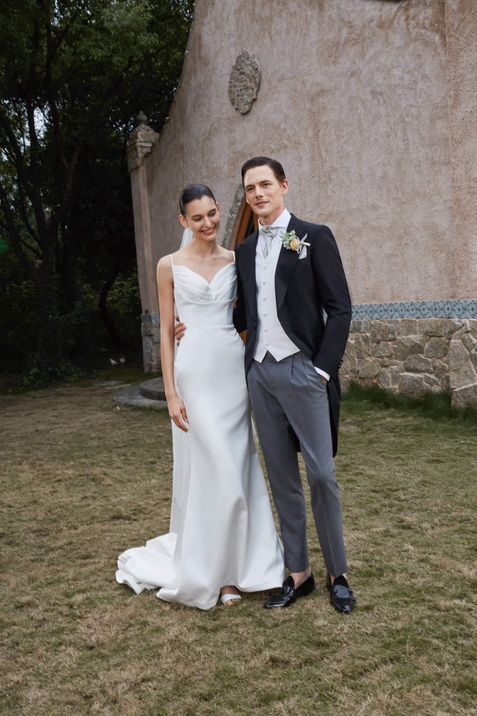 London couples posing for a picture while the man is wearing a bespoke London wedding suit from Mccann Bespoke